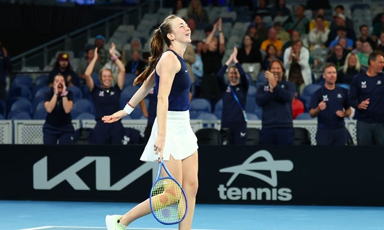 Mika Stojsavljevic smiling on court while holding her tennis racket after winning her first Billie Jean King Cup match on debut