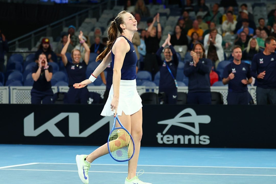 Mika Stojsavljevic smiling on court while holding her tennis racket after winning her first Billie Jean King Cup match on debut