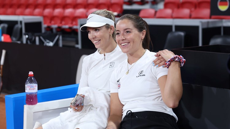 Katie Boulter and Jodie Burrage sat down, smiling and holding hands at the Billie Jean King Cup Qualifiers