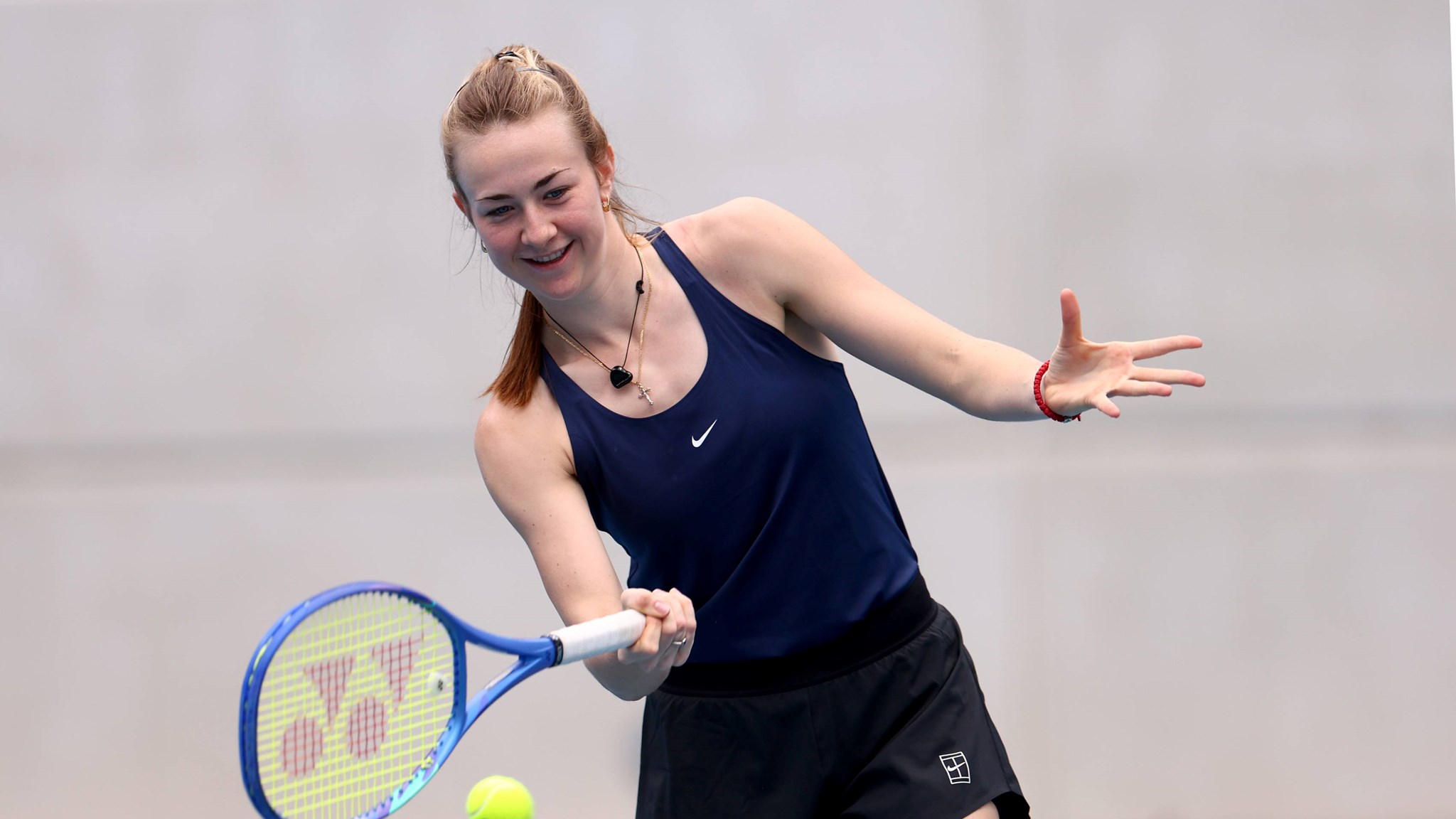 Mika Stojsavljevic smiles as she hits a forehand in practice at the Billie Jean King Cup