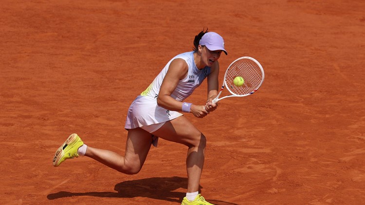 Iga Swiatek hits a backhand at the 2025 Roland Garros