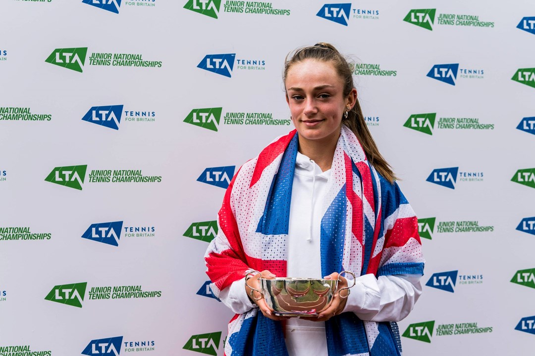 Isabelle Lacy hiding the 18U Junior National Championships trophy