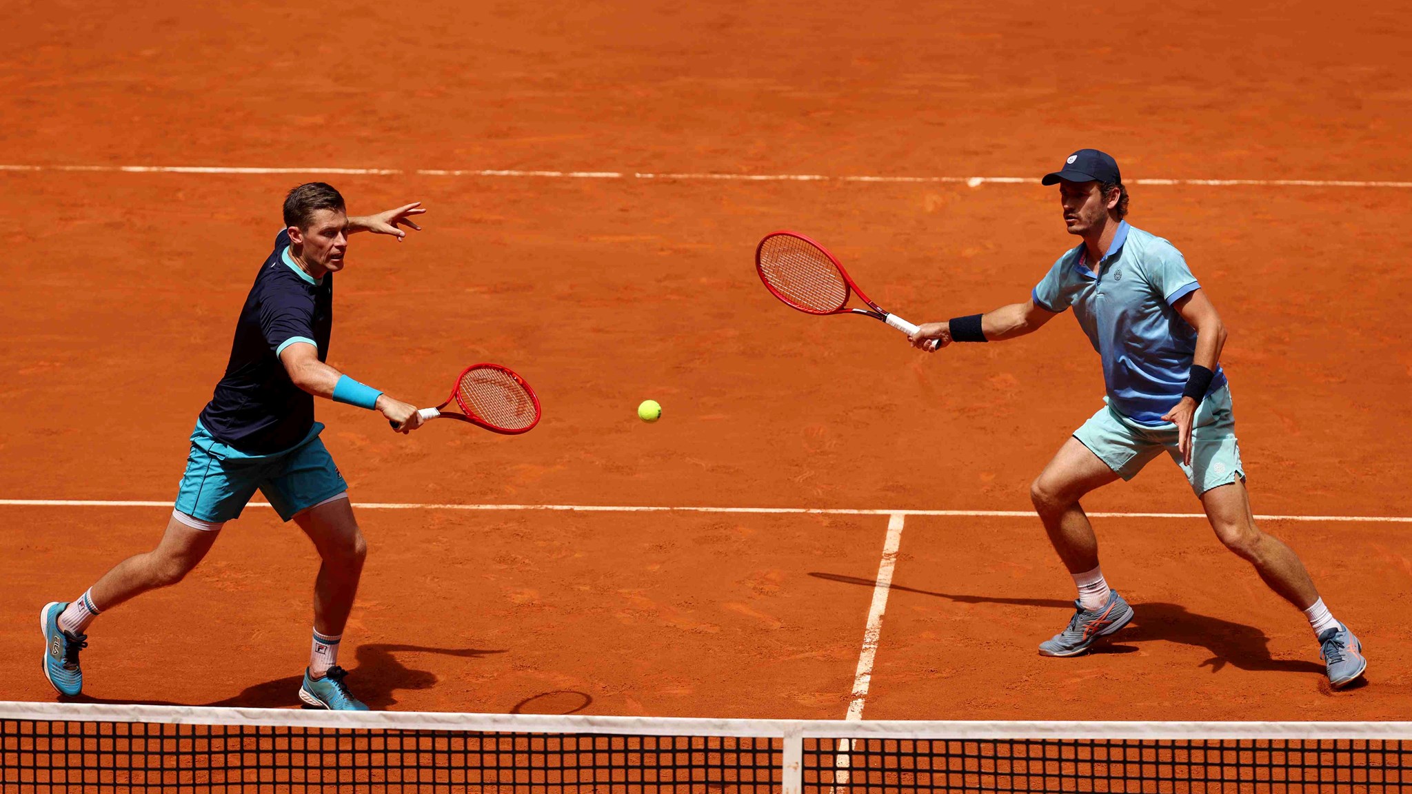 Neal Skupski hitting a backhand slice on court at the Madrid alongside Wesley Koolhof