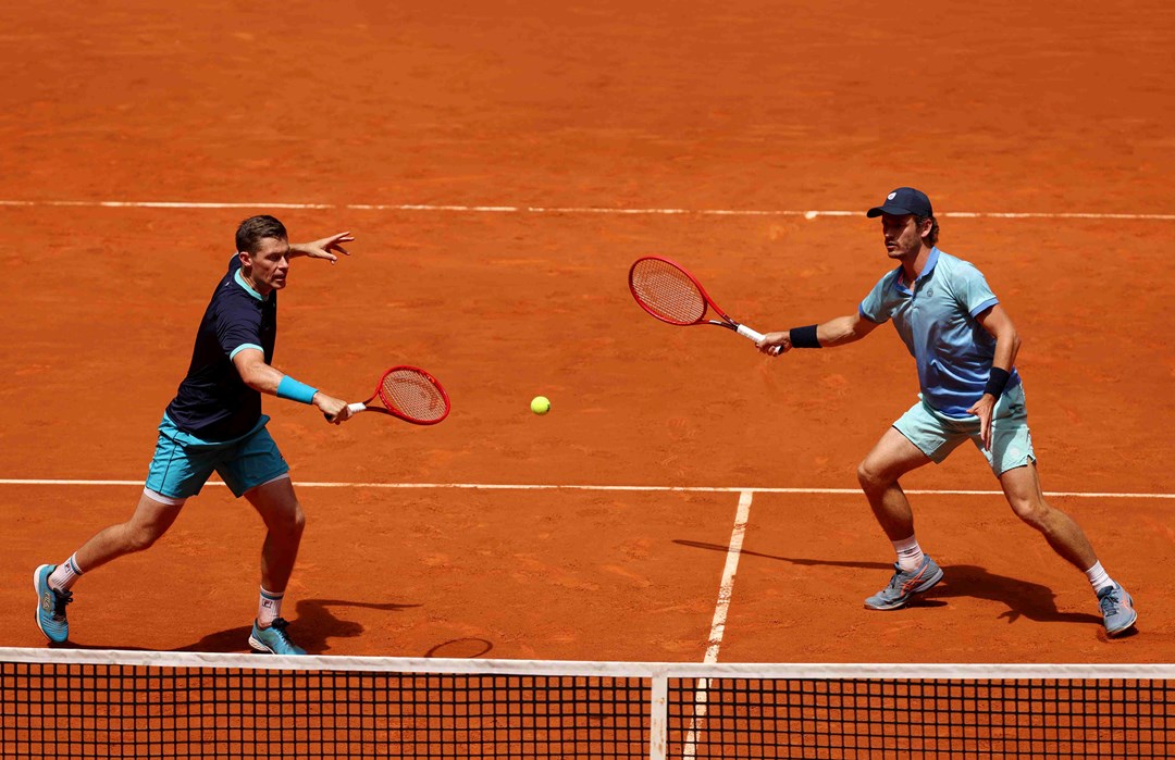 Neal Skupski hitting a backhand slice on court at the Madrid alongside Wesley Koolhof