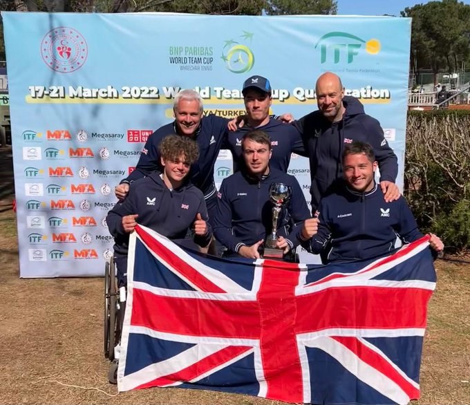 Three paralympic players holding the Great Britain flag