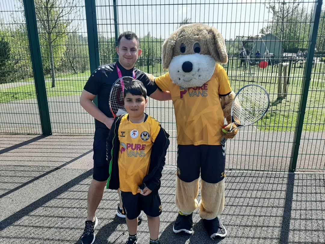 Newport County's mascot, Spytty the dog, posing for a photo with others at the Easter Fun Day held at Newport Tennis Centre