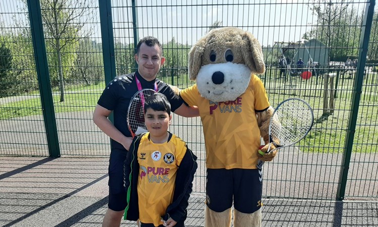 Newport County's mascot, Spytty the dog, posing for a photo with others  at the Easter Fun Day held at Newport Tennis Centre