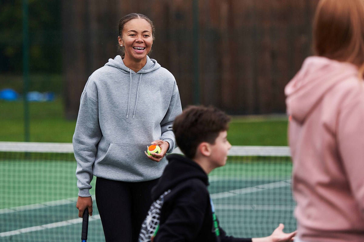 Player-laughing-on-court-with-friends.jpg