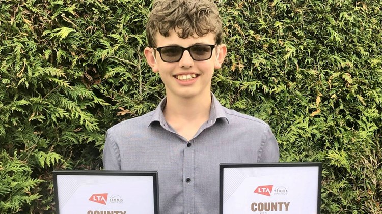 Deaf tennis player Charlie Denton holding LTA Awards