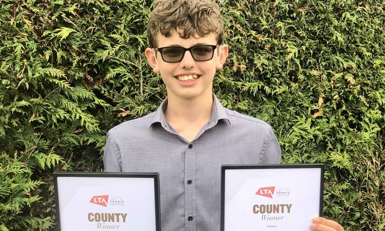 Deaf tennis player Charlie Denton holding LTA Awards
