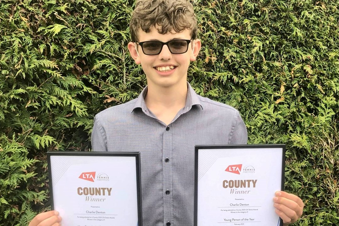 Deaf tennis player Charlie Denton holding LTA Awards