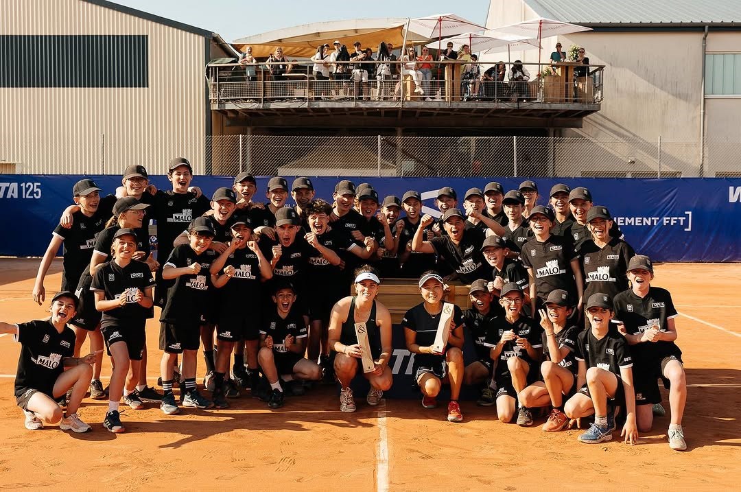 Maia Lumsden celebrating the Saint Malo Challenger doubles title with her partner and the ball crew
