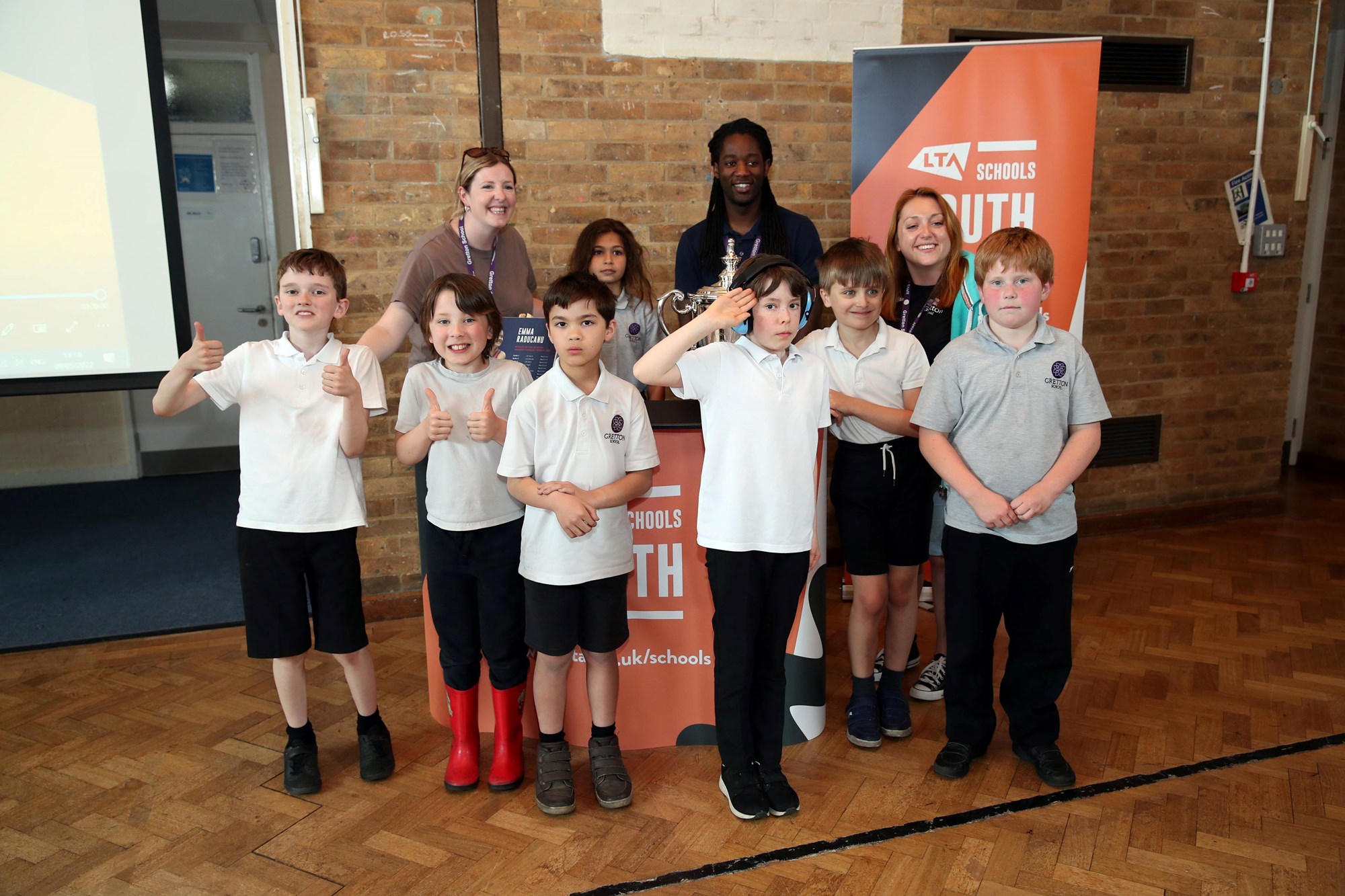 Pupils of Gretton Primary School posing with Emma Raducanu's US Open Trophy Tour