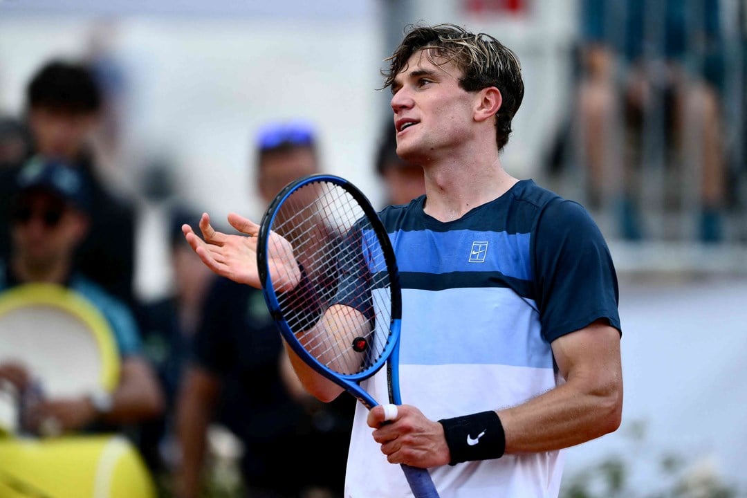 Jack Draper holding his racket and smiling after winning his fourth round match at the Italian Open