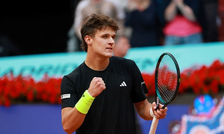 Czech tennis player Jakub Mensik holding his tennis racket and clenching his fist