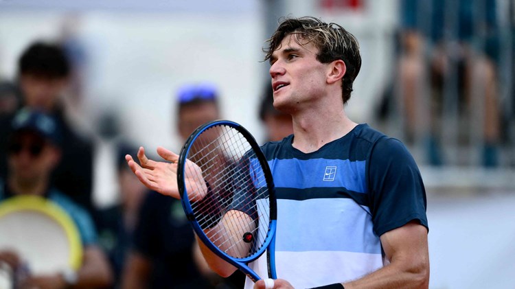 Jack Draper holding his racket and smiling after winning his fourth round match at the Italian Open
