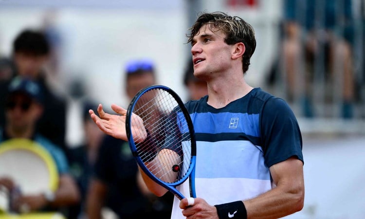 Jack Draper holding his racket and smiling after winning his fourth round match at the Italian Open