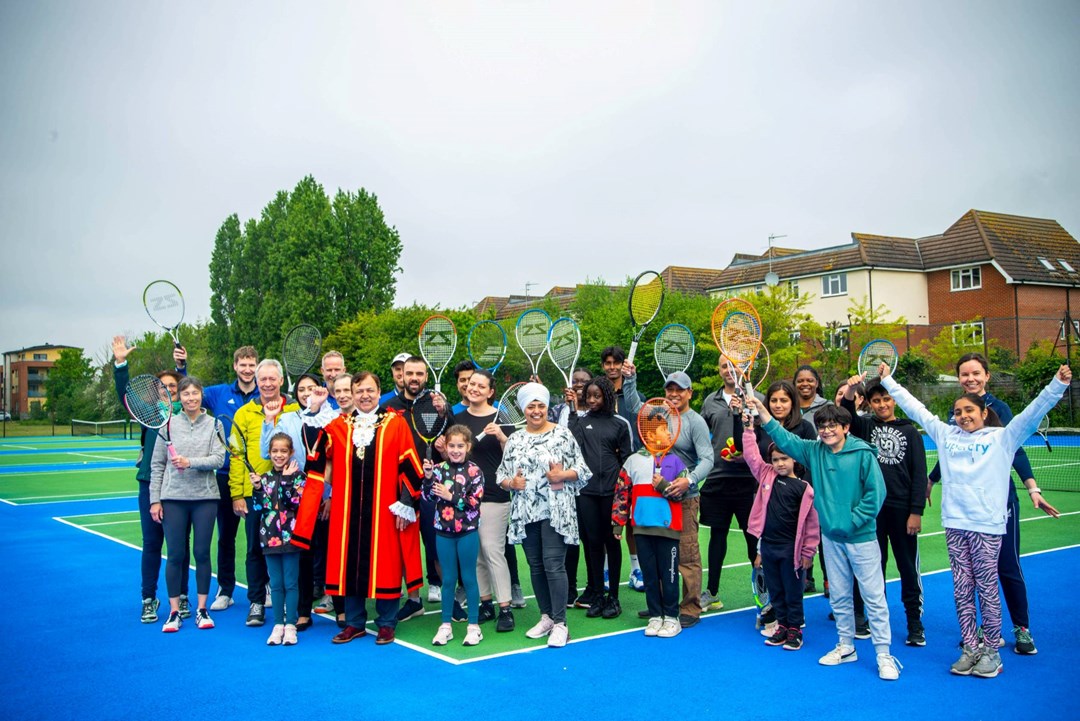 Members of the public raise their rackets for a photograph during the Rosendale Park re-opening in Hillingdon