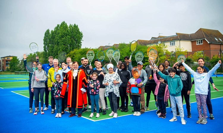 Members of the public raise their rackets for a photograph during the Rosendale Park re-opening in Hillingdon