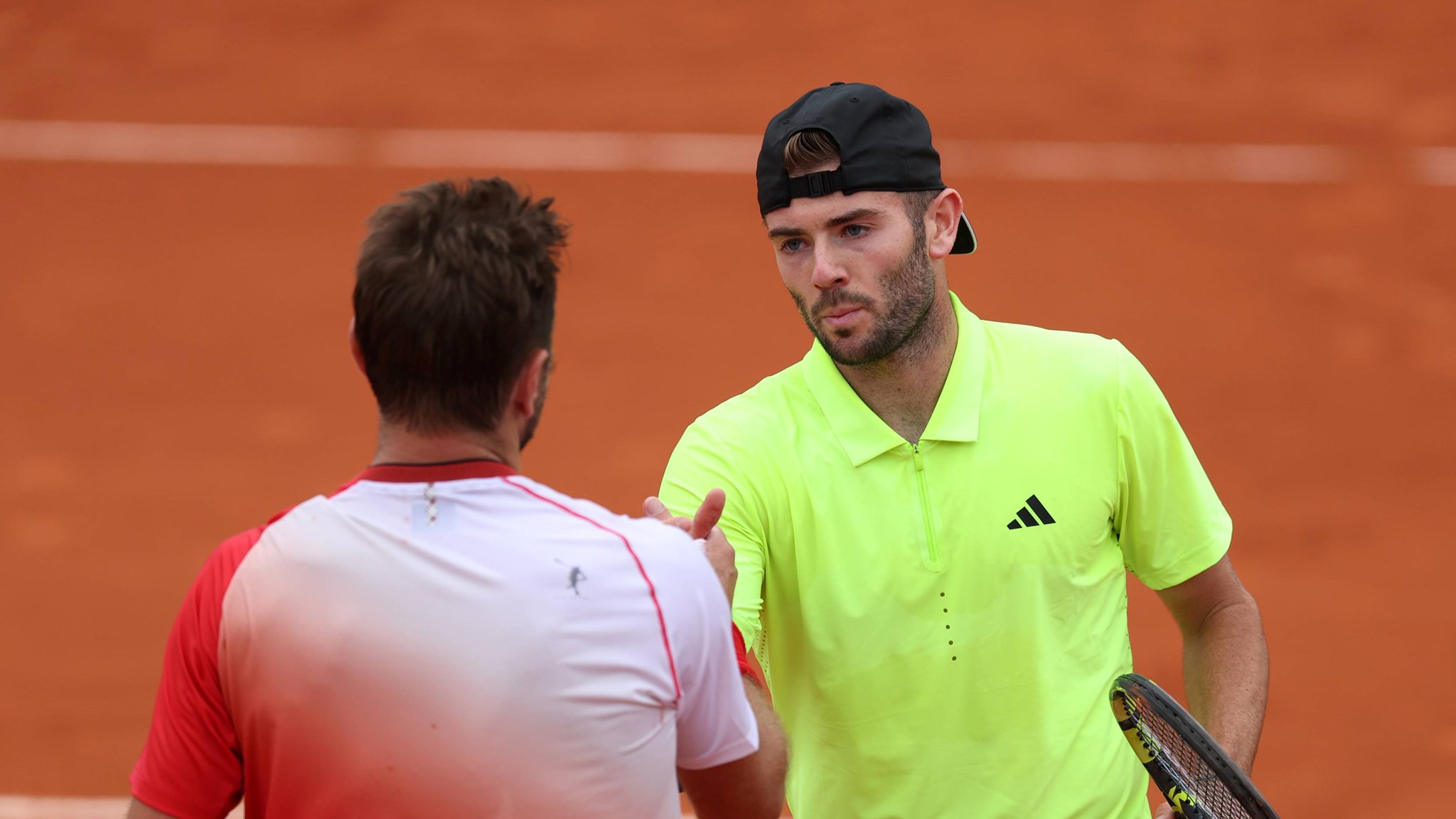 Jacob Fearnley shakes hands with Stan Wawrinka at Roland Garros