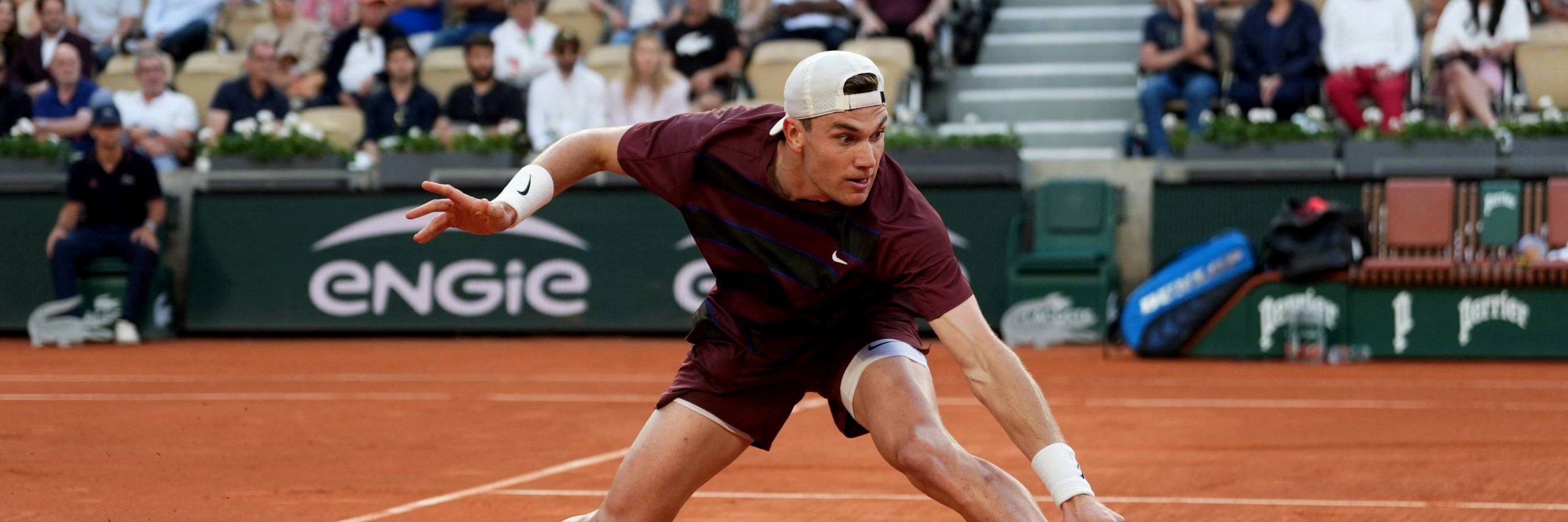 Jack Draper slides to hit a backhand against Alexander Bublik at Roland Garros