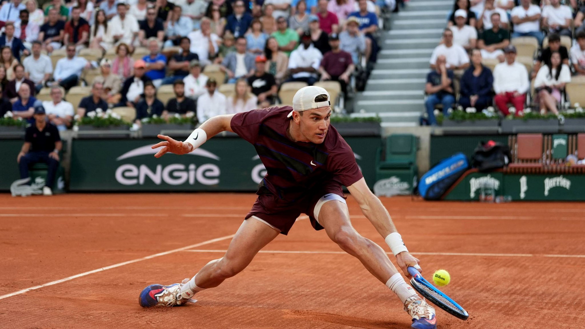 Jack Draper slides to hit a backhand against Alexander Bublik at Roland Garros