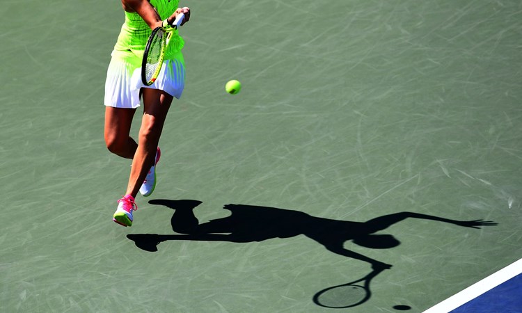 A female tennis player hitting a shot on a hard court