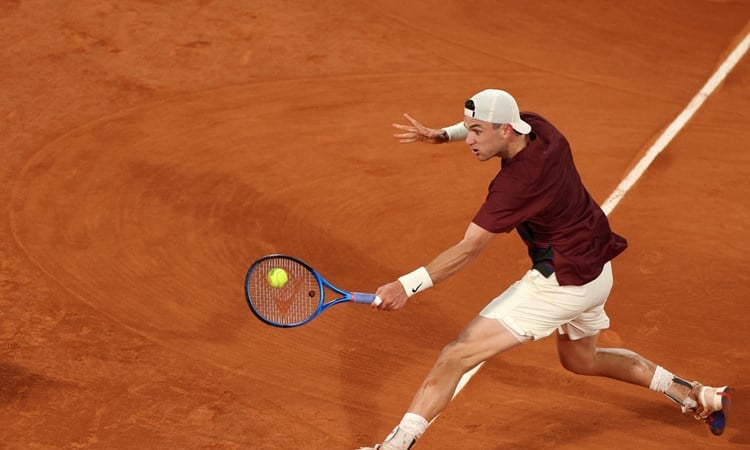 Jack Draper sliding on the clay to hit a backhand