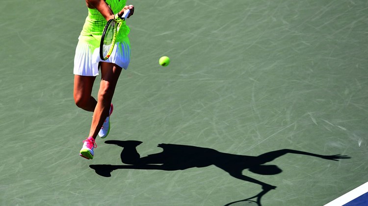 A female tennis player hitting a shot on a hard court
