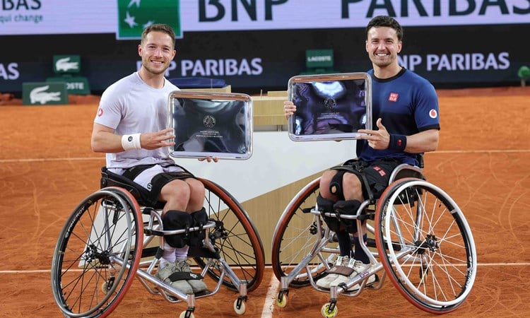 Alfie Hewett and Gordon Reid smiling while holding their winners trophies at Roland Garros