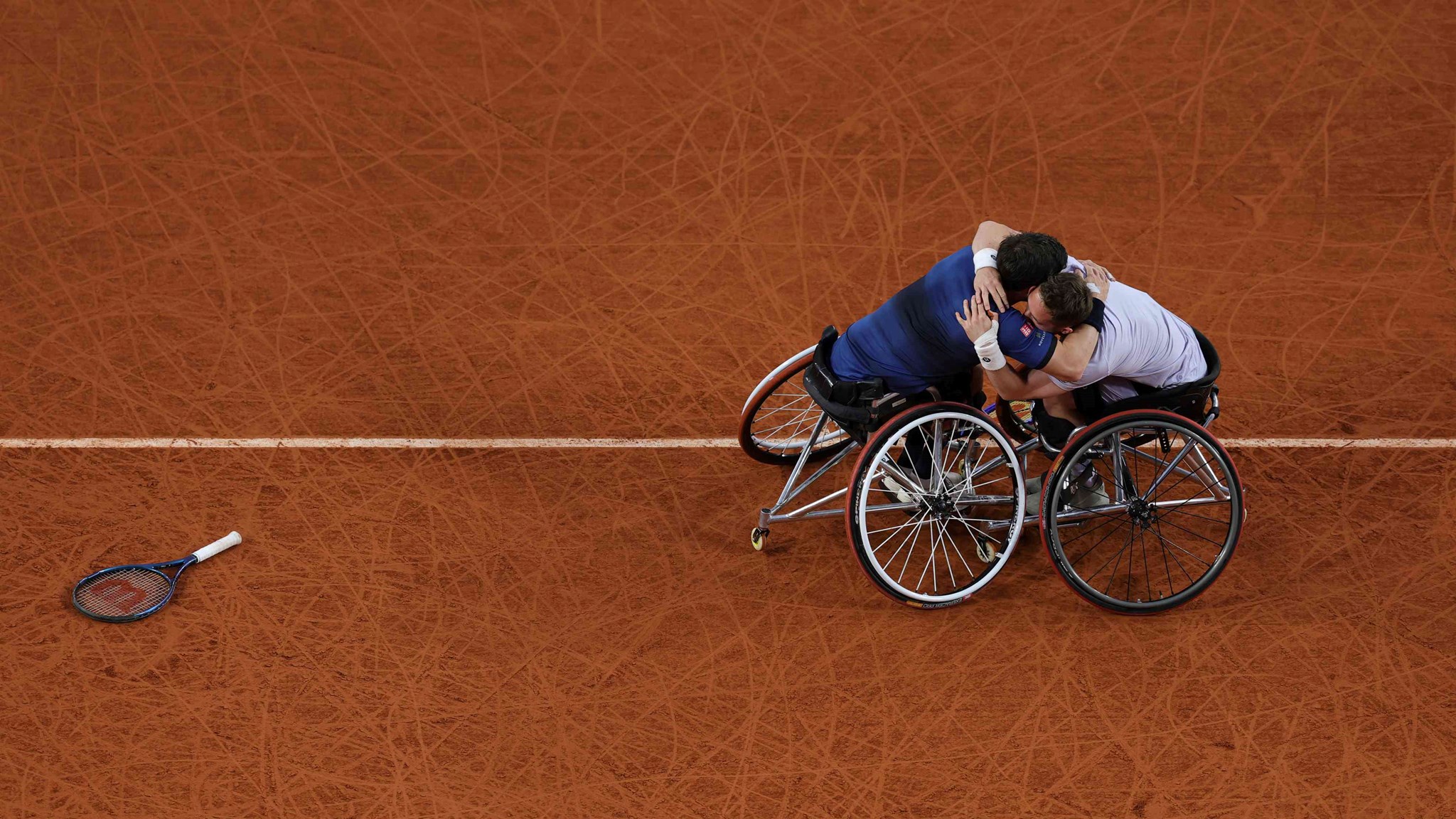Alfie Hewett and Gordon Reid hugging each other on court at Roland Garros