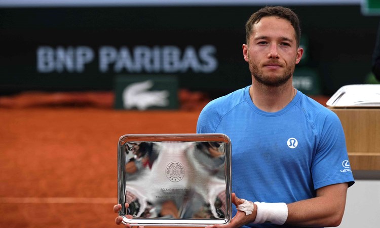 Alfie Hewett holding his runner-up trophy on court at the Roland Garros men's wheelchair singles final
