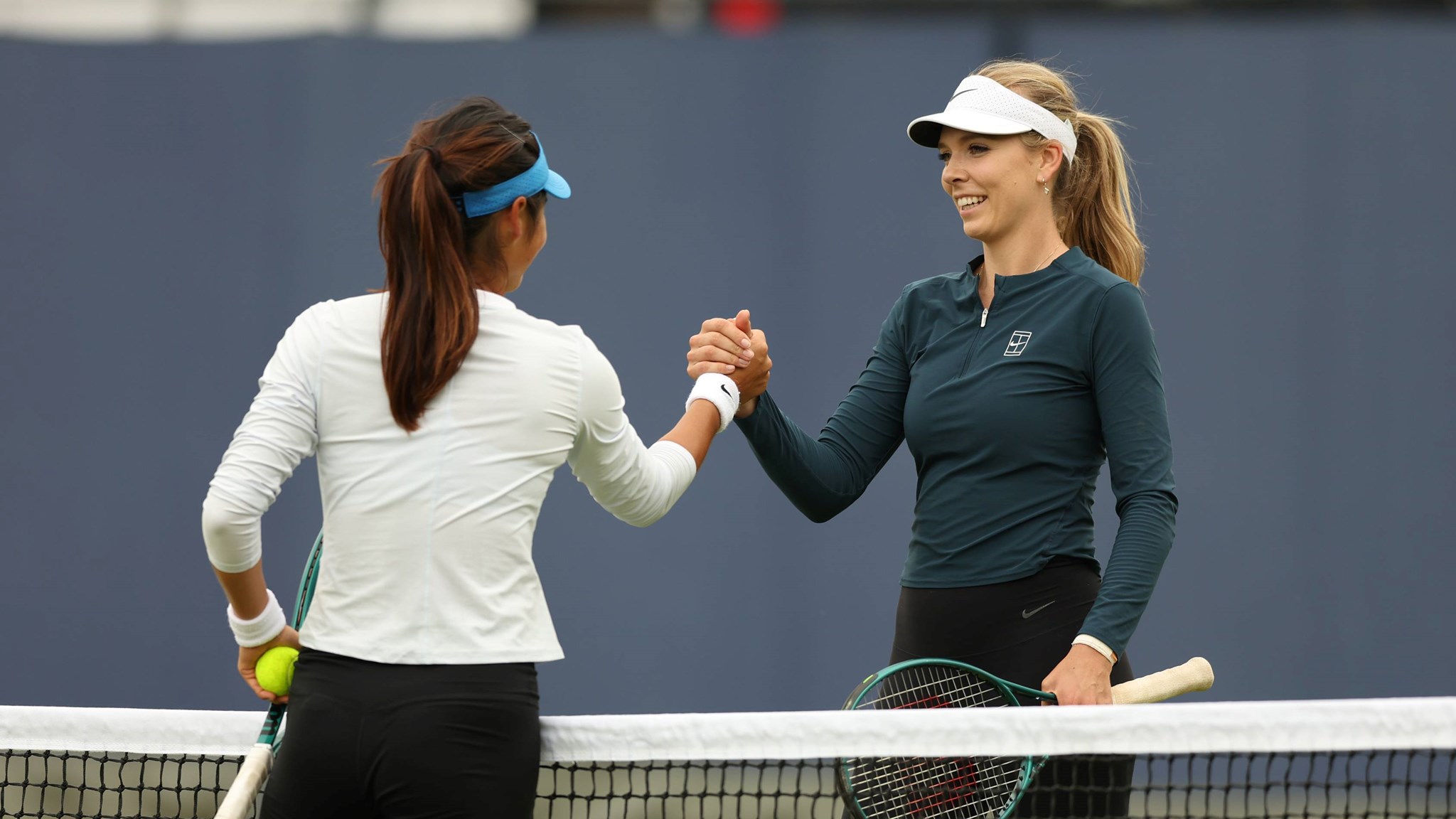 Katie Boulter and Emma Raducanu high five during practice at the HSBC Championships