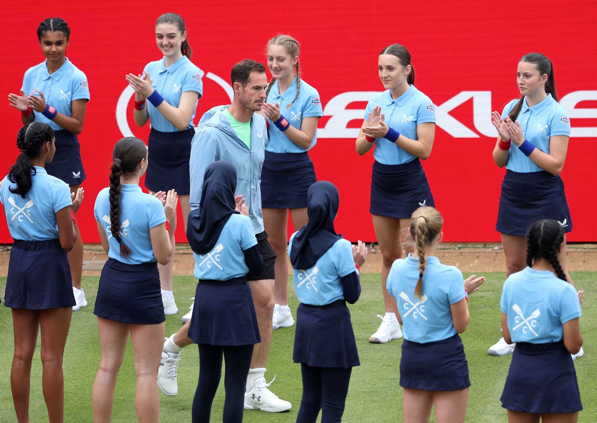 Andy Murray being surrounded and clapped by the ball kids as he walks onto the Andy Murray Arena at the HSBC Championships