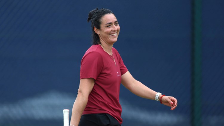 Ons Jabeur smiles whilst training with Emma Raducanu