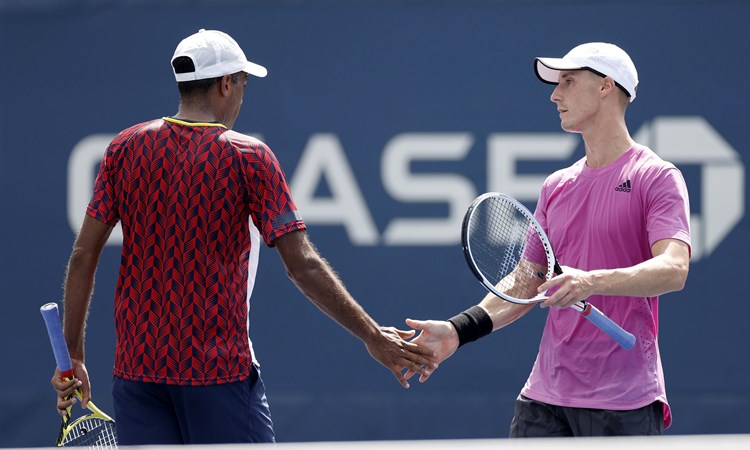 Joe Salisbury and Rajeev Ram interacting during their first round match at the 2022 US Open
