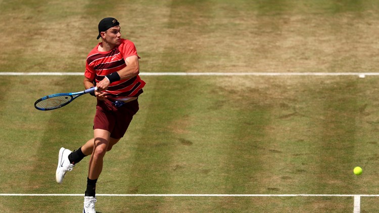 Jack Draper raises off the ground as he hits a forehand on the grass at the HSBC Championships