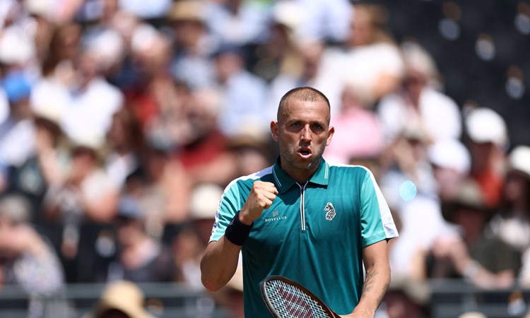 Dan Evans fist pumping in celebration while holding his racket in his other hand