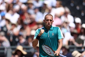 Dan Evans fist pumping in celebration while holding his racket in his other hand
