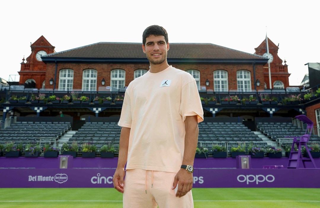 Carlos Alcaraz stood on court infront of the Queen's Club at the cinch Championships