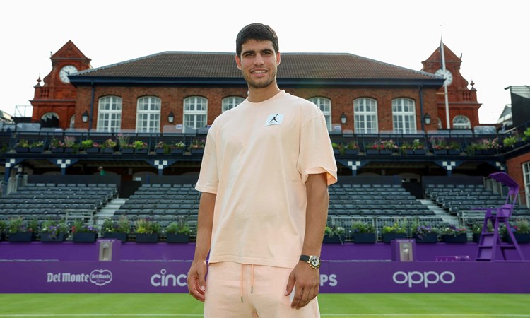 Carlos Alcaraz stood on court infront of the Queen's Club at the cinch Championships