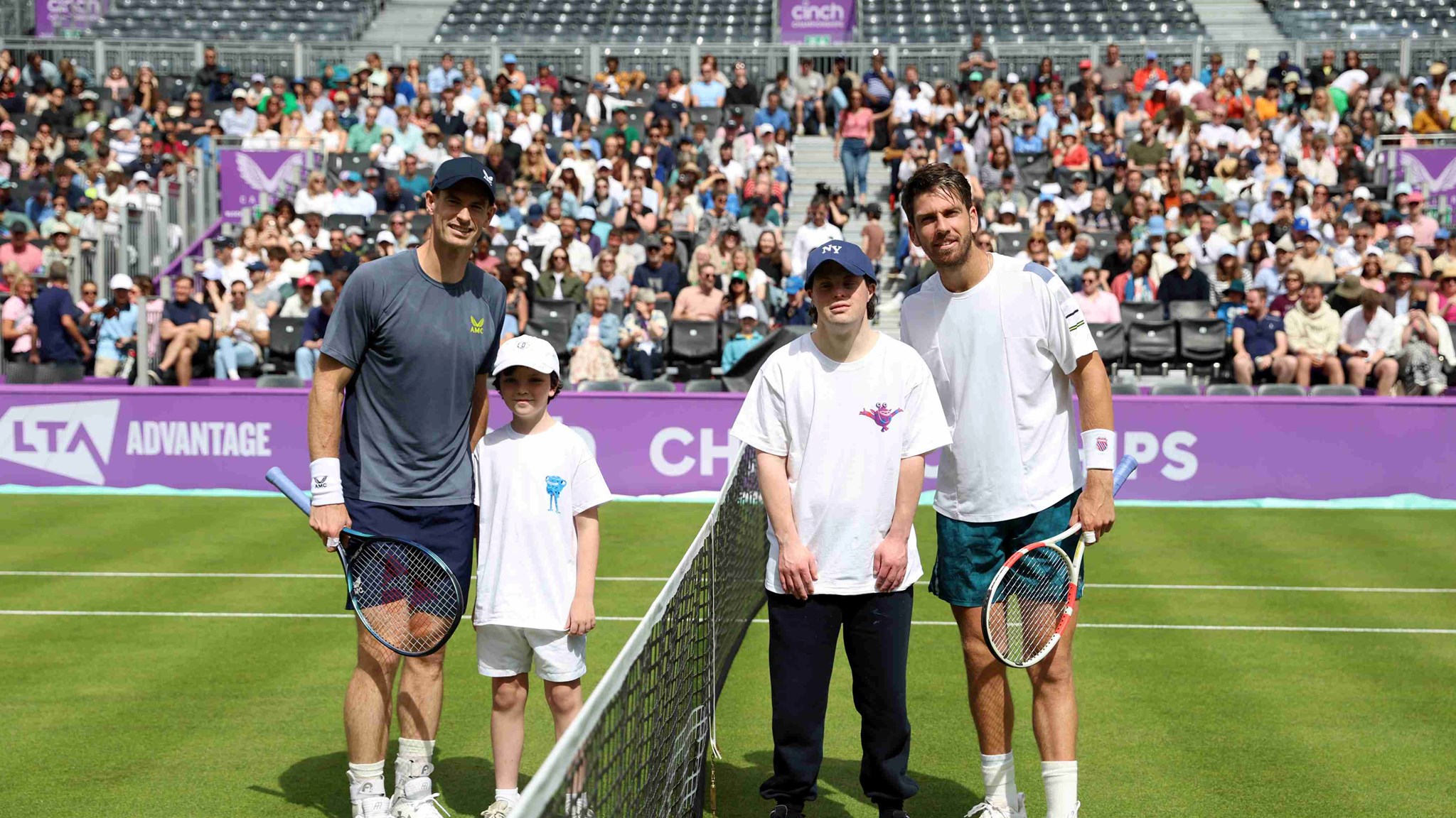 Andy Murray and Cam Norrie stood either side of a tennis net next to two children on court at the cinch Championships