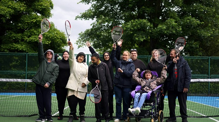 Players on court raising a racket at a disability tennis session and Lister Park courts