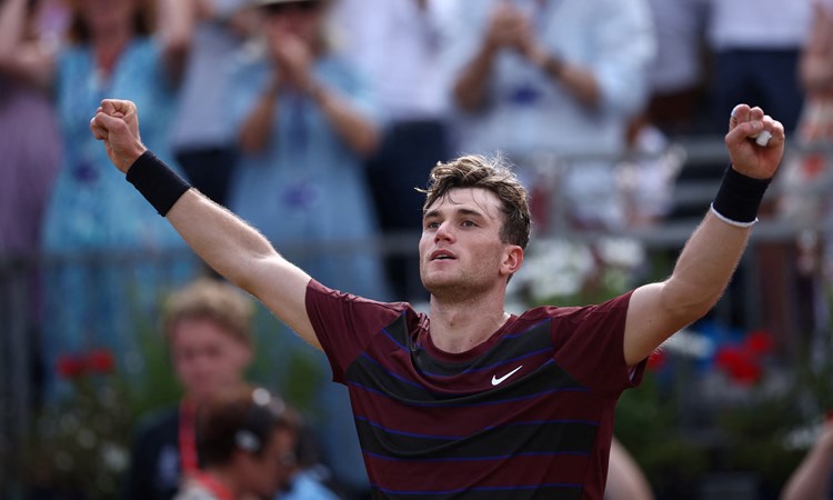 Jack Draper with both hands in the air celebrating a win