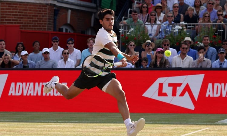 Carlos Alcaraz leaps to reach a volley on the grass court at the HSBC Championships