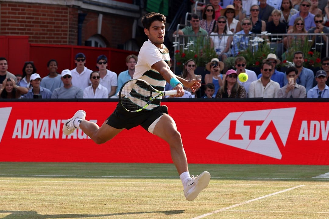 Carlos Alcaraz leaps to reach a volley on the grass court at the HSBC Championships