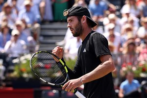 Jacob Fearnley pumping his fist in celebration while holding his racket in the other hand