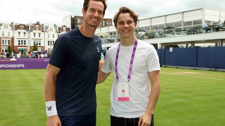 Andy Murray stood on a practice court at the cinch Championships alongside McLaren Racing driver Oscar Piastri