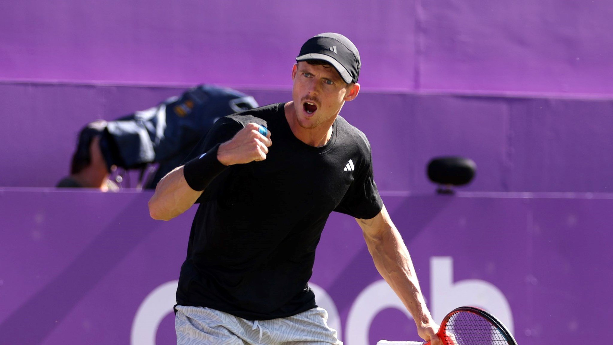Billy Harris clenching his fist and cheering on court with cinch championships branding behind him