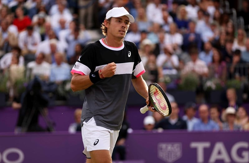 Alex De Minaur clenching his fist while holding a racket in his other in celebration on court at the cinch championships
